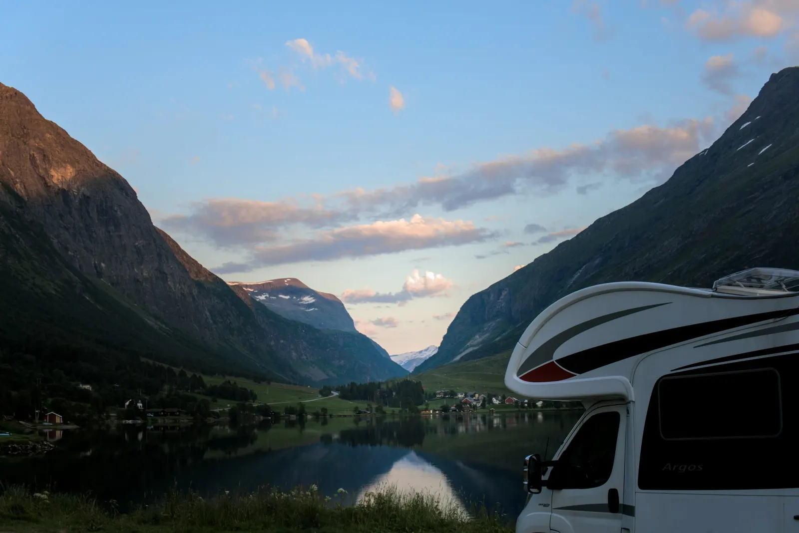 Autocamper ved en fjord omgivet af bjerge